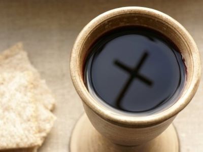 image d'une coupe rempli de vin dans laquelle se reflète une croix